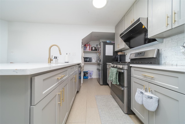 240-48 Oak Park Dr Unit A, Douglaston, NY 11362 - kitchen featuring appliances with stainless steel finishes, tasteful backsplash, light tile patterned floors, light stone countertops, and a sink