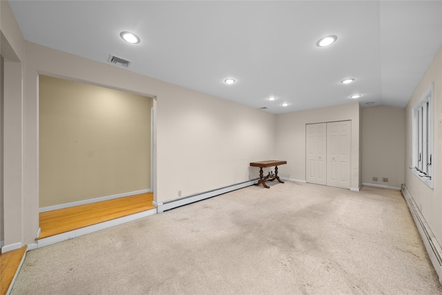 basement featuring a baseboard heating unit, visible vents, recessed lighting, baseboard heating, and baseboards