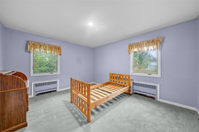 carpeted bedroom with recessed lighting, baseboards, and radiator heating unit
