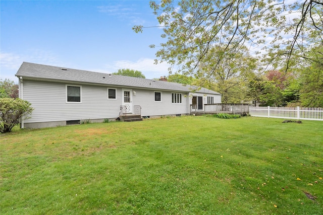 back of property featuring a lawn, a chimney, a wooden deck, and fence