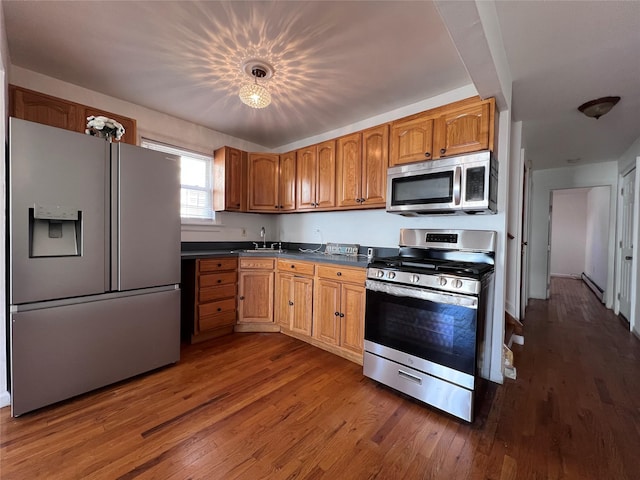 109-41 132nd St, South Ozone Park, NY 11420 - kitchen featuring stainless steel appliances, dark countertops, dark wood-style flooring, a sink, and baseboard heating