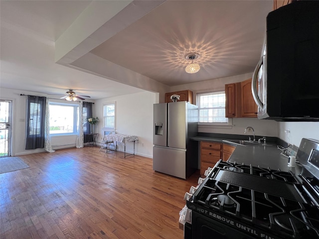 109-41 132nd St, South Ozone Park, NY 11420 - kitchen with stainless steel appliances, a sink, brown cabinetry, and plenty of natural light