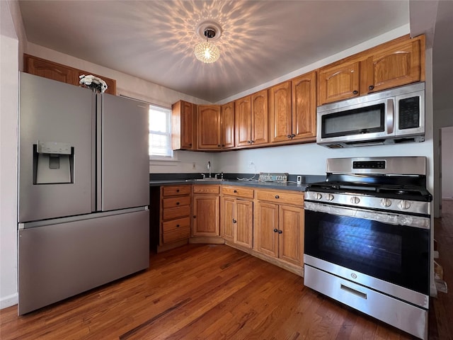 109-41 132nd St, South Ozone Park, NY 11420 - kitchen featuring appliances with stainless steel finishes, dark countertops, a sink, and brown cabinets