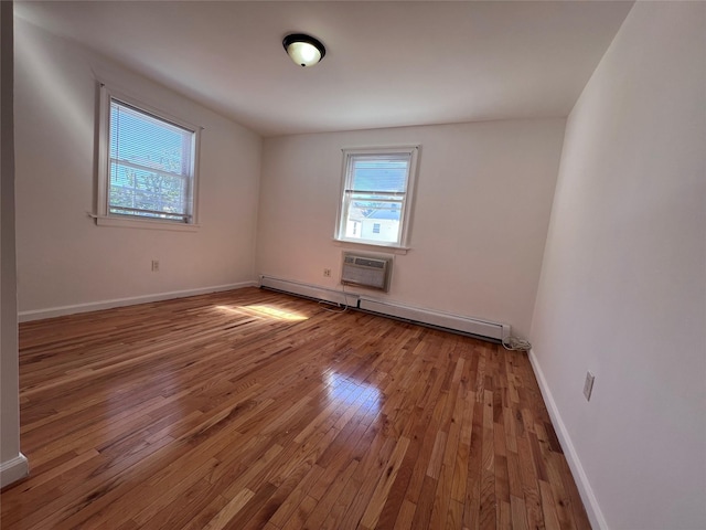 109-41 132nd St, South Ozone Park, NY 11420 - unfurnished room with baseboard heating, wood-type flooring, baseboards, and a wall unit AC