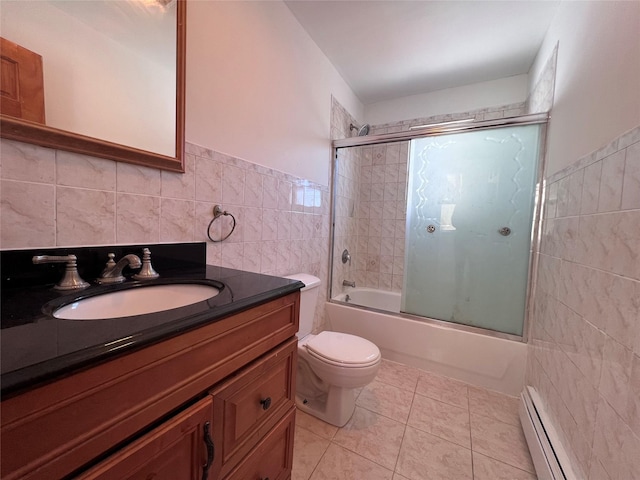 109-41 132nd St, South Ozone Park, NY 11420 - bathroom featuring tile walls, a baseboard heating unit, bath / shower combo with glass door, vanity, and toilet