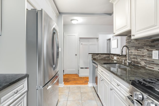 70 Underhill Ave Unit 1A, West Harrison, NY 10604 - kitchen with stainless steel appliances, a sink, backsplash, white cabinetry, and dark stone countertops