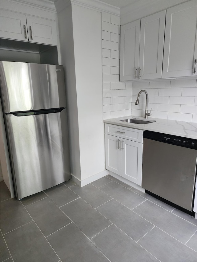 kitchen with tile patterned floors, stainless steel appliances, tasteful backsplash, and a sink