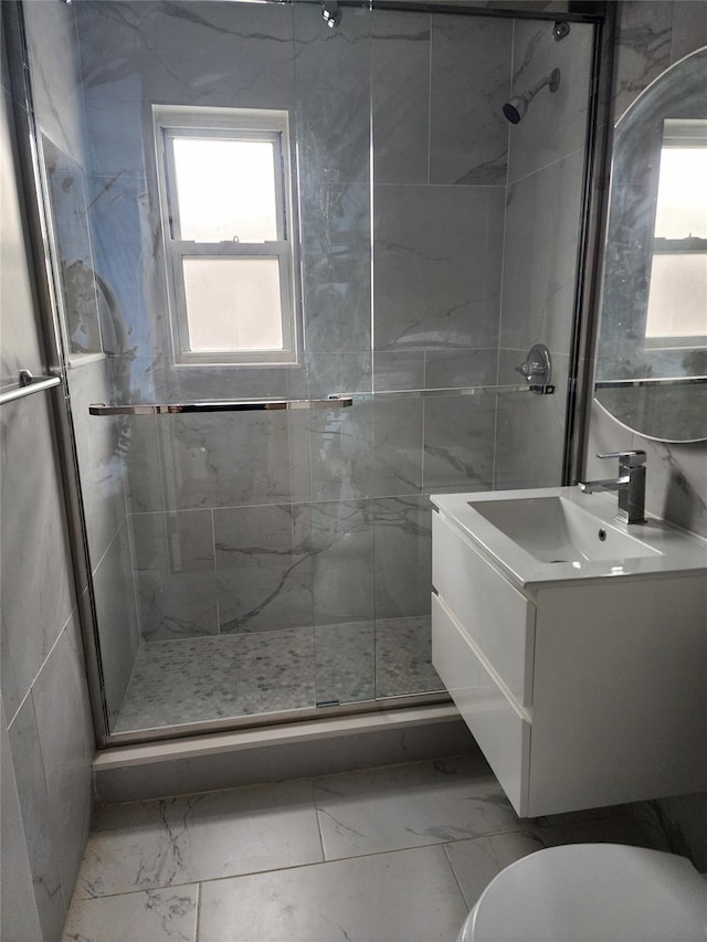 bathroom with vanity, marble finish floor, a stall shower, and a healthy amount of sunlight