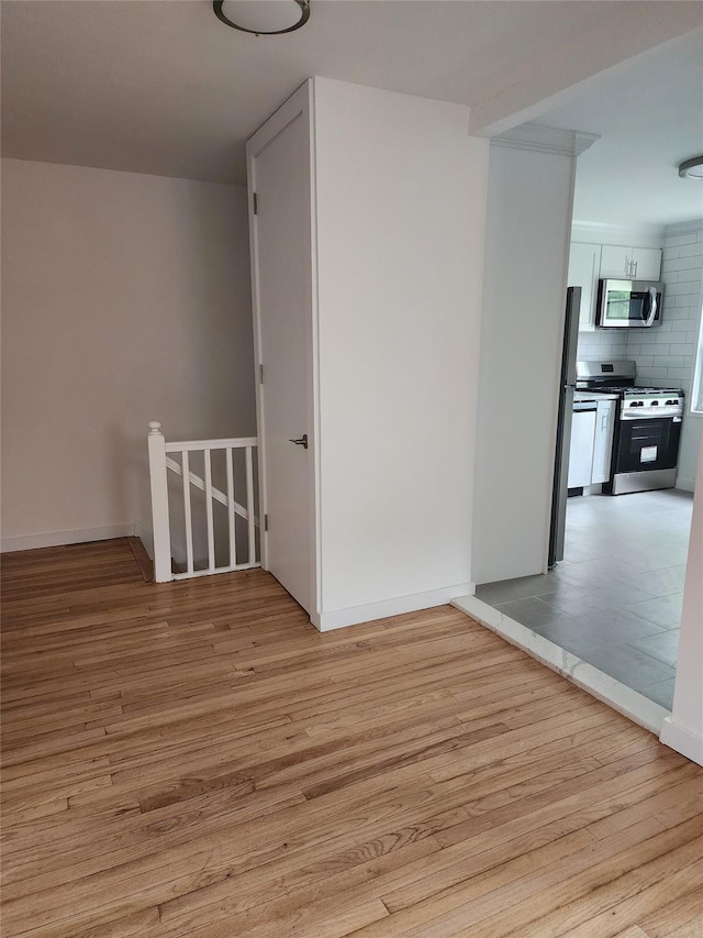 additional living space featuring light wood-style flooring