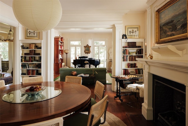 dining room featuring crown molding, dark wood finished floors, built in features, and a fireplace with flush hearth