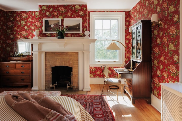 sitting room featuring wallpapered walls, plenty of natural light, and hardwood / wood-style flooring