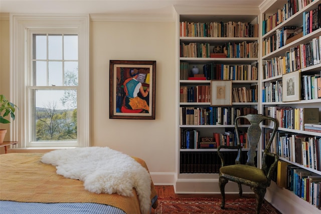 bedroom featuring ornamental molding, baseboards, and wood finished floors