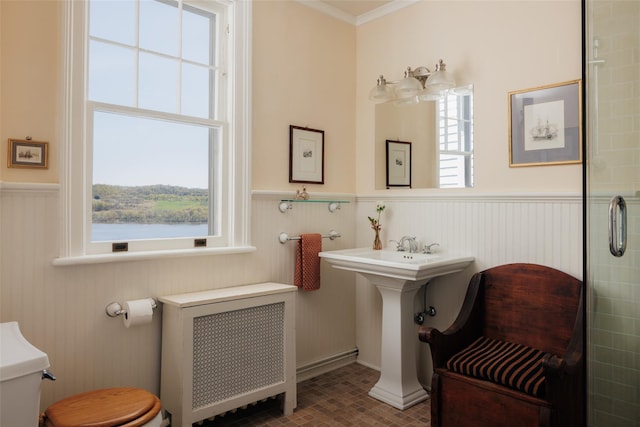 bathroom with toilet, a wainscoted wall, radiator heating unit, crown molding, and brick patterned floor