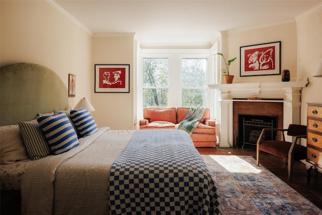 bedroom featuring crown molding, wood finished floors, and a fireplace with flush hearth