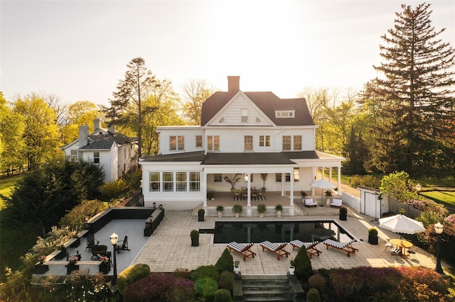 back of property featuring a chimney, fence, outdoor dining area, an outdoor hangout area, and a patio area