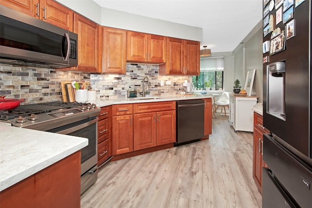 680 W Boston Post Rd Unit 3R, Mamaroneck, NY 10543 - kitchen with black appliances, light wood-style floors, brown cabinets, and tasteful backsplash