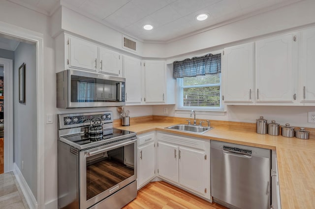 7 Jacqueline Ct, Port Jefferson Station, NY 11776 - kitchen with stainless steel appliances, white cabinetry, light wood-style flooring, and recessed lighting