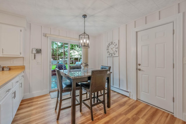 7 Jacqueline Ct, Port Jefferson Station, NY 11776 - dining area featuring a decorative wall, a chandelier, light wood finished floors, and a baseboard heating unit