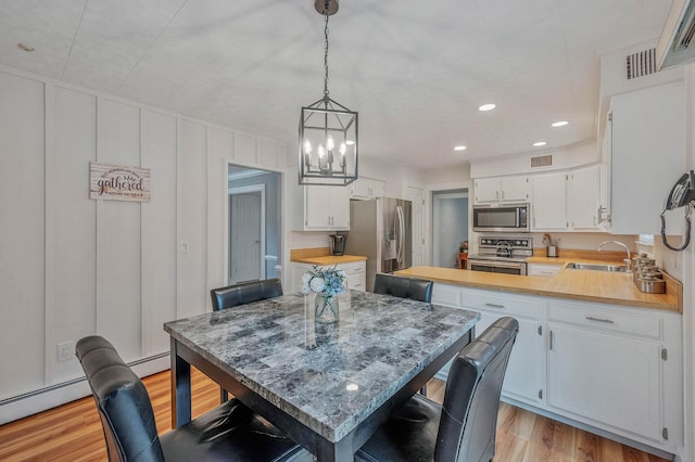 7 Jacqueline Ct, Port Jefferson Station, NY 11776 - dining area featuring a chandelier, light wood-type flooring, and recessed lighting