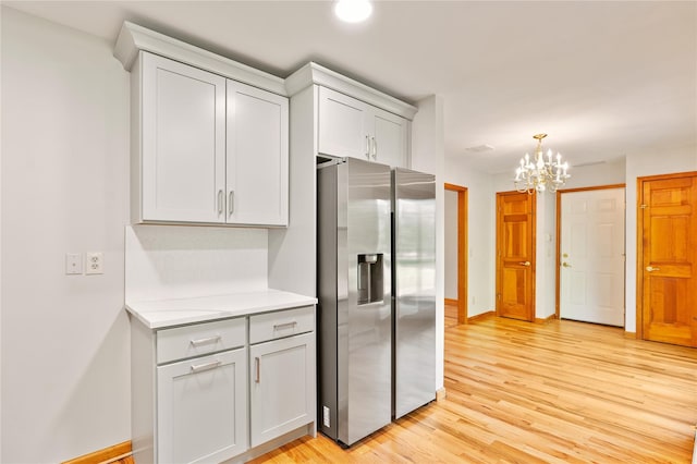 521 Plattekill Ardonia Rd, Wallkill, NY 12589 - kitchen with stainless steel fridge, light wood-type flooring, light countertops, a chandelier, and baseboards