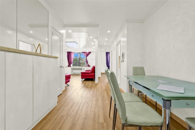 dining area featuring light wood-style flooring, radiator, and ornamental molding