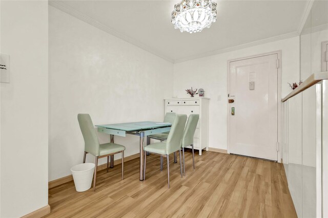 dining room featuring a chandelier, wood finished floors, crown molding, and baseboards