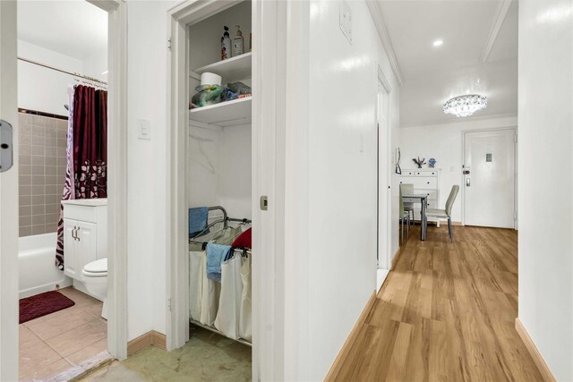 hall featuring light wood-type flooring and baseboards