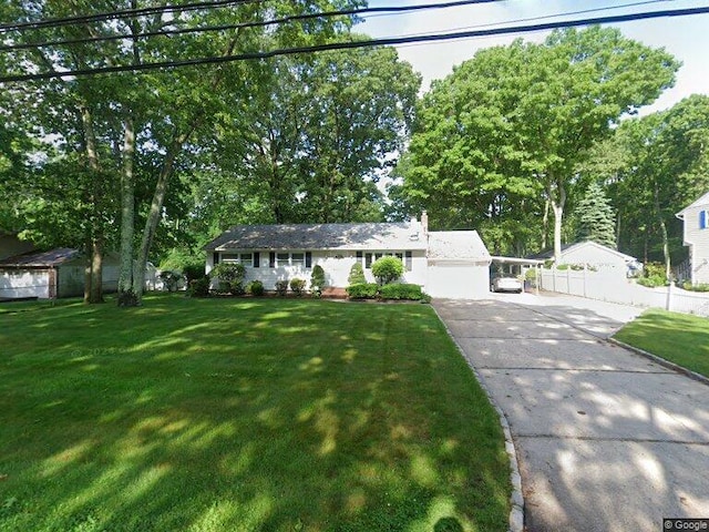 ranch-style home with concrete driveway and a front yard