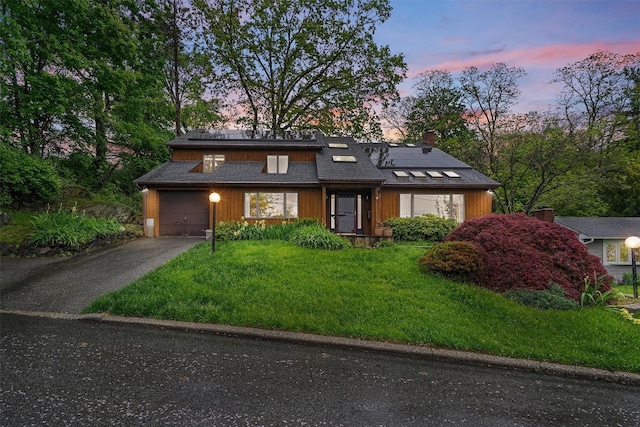8 Wolf Rd, Croton-On-Hudson, NY 10520 - mid-century modern home with solar panels, asphalt driveway, a garage, and a front lawn