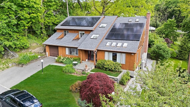 8 Wolf Rd, Croton-On-Hudson, NY 10520 - view of front of home featuring roof with shingles, a chimney, solar panels, a front lawn, and a garage