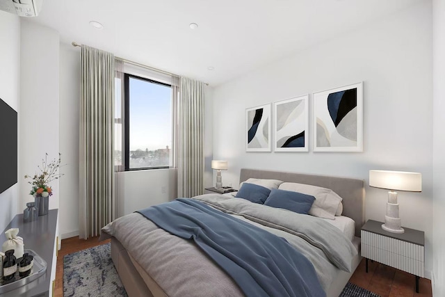 bedroom featuring wood finished floors, baseboards, a wall mounted AC, and recessed lighting