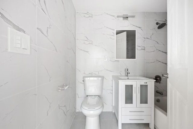 full bathroom featuring vanity, toilet, bathtub / shower combination, and tile walls