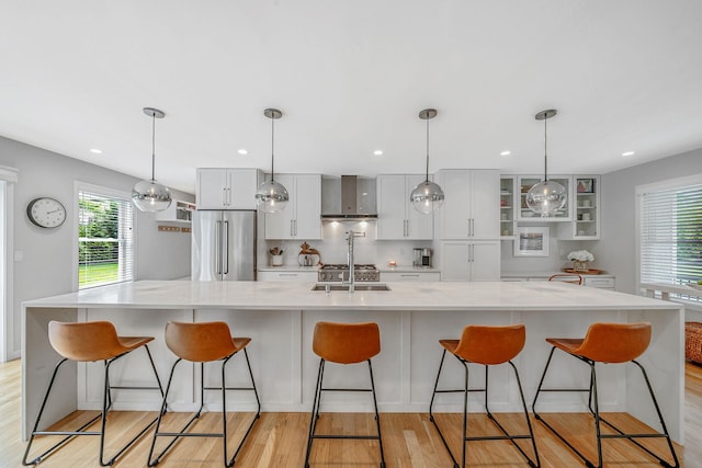 56 N Woods Rd, Baiting Hollow, NY 11933 - kitchen featuring high end fridge, light wood-style flooring, a breakfast bar area, glass insert cabinets, and recessed lighting