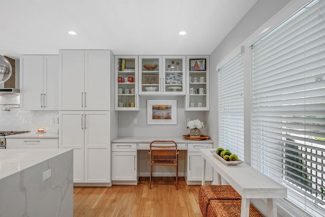 56 N Woods Rd, Baiting Hollow, NY 11933 - kitchen with light wood-style floors, tasteful backsplash, glass insert cabinets, recessed lighting, and light stone counters