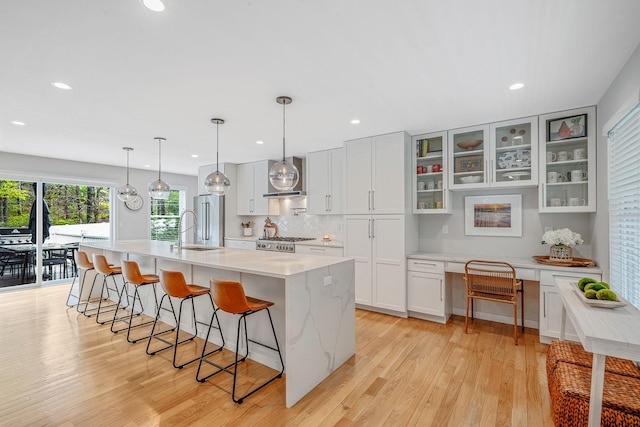 56 N Woods Rd, Baiting Hollow, NY 11933 - kitchen featuring high quality fridge, a sink, a breakfast bar area, light wood-type flooring, and range