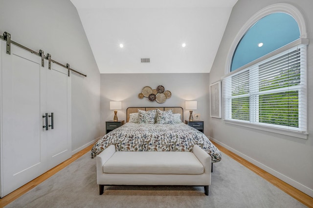 56 N Woods Rd, Baiting Hollow, NY 11933 - bedroom with a barn door, wood finished floors, baseboards, high vaulted ceiling, and recessed lighting