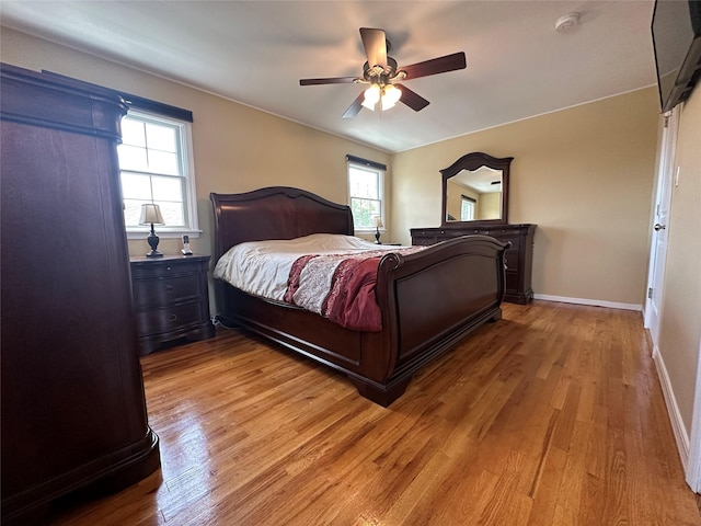 bedroom featuring baseboards, light wood-style floors, and a ceiling fan