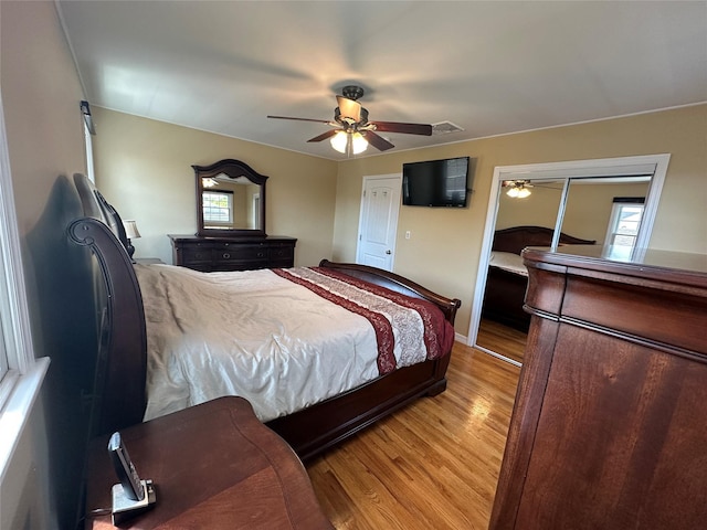 bedroom featuring multiple windows, ceiling fan, and light wood-type flooring