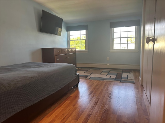 bedroom with baseboards and wood finished floors