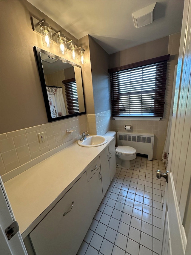 bathroom featuring tile walls, toilet, radiator heating unit, tile patterned floors, and vanity