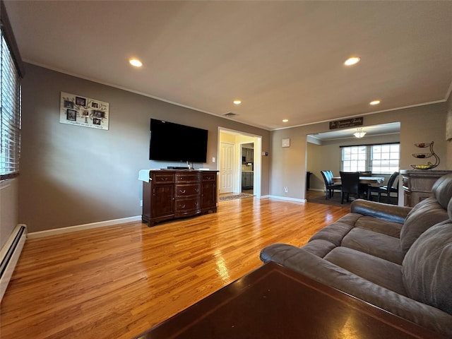 living area with crown molding, recessed lighting, baseboard heating, and light wood-style floors