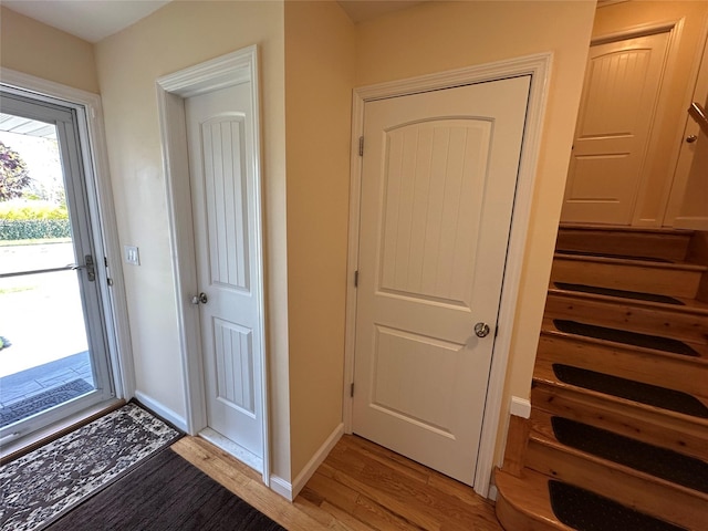 foyer with baseboards and light wood-type flooring