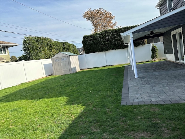 view of yard with a ceiling fan, a patio area, a storage shed, and a fenced backyard