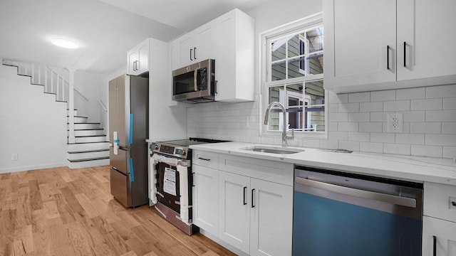 2227 Boller Ave, Bronx, NY 10475 - kitchen with stainless steel appliances, a sink, white cabinetry, light wood-type flooring, and light stone countertops