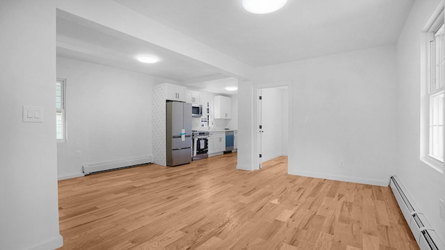 2227 Boller Ave, Bronx, NY 10475 - unfurnished living room featuring baseboard heating, light wood finished floors, baseboards, and a baseboard heating unit