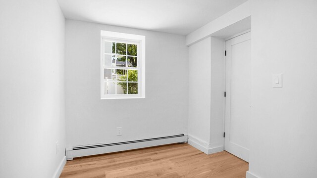 2227 Boller Ave, Bronx, NY 10475 - unfurnished room featuring a baseboard heating unit, wood finished floors, and baseboards