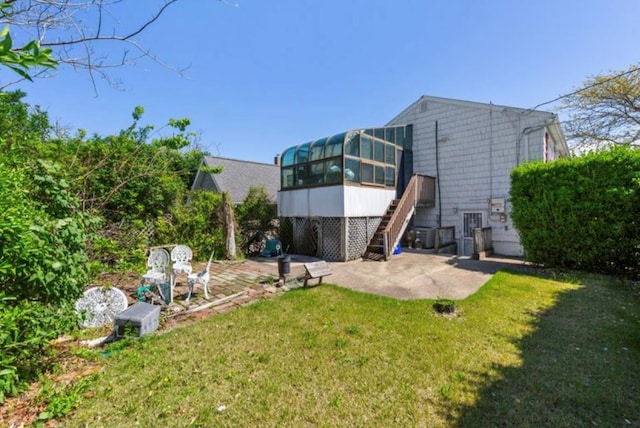 1001 Van Buren St, Baldwin, NY 11510 - back of property with a sunroom, a patio area, a lawn, and stairway