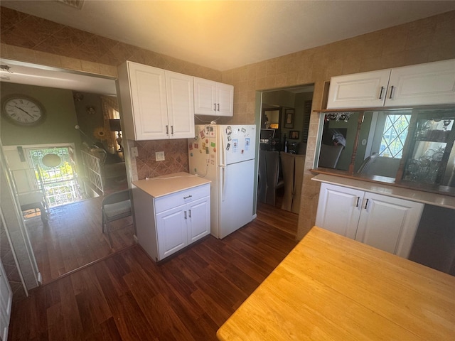 1001 Van Buren St, Baldwin, NY 11510 - kitchen featuring freestanding refrigerator, dark wood-style flooring, white cabinets, healthy amount of natural light, and tile walls