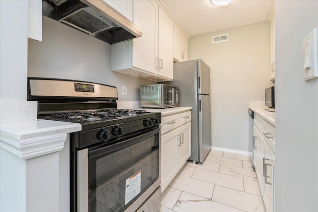 152 Artist Lake Dr Unit 152, Middle Island, NY 11953 - kitchen featuring appliances with stainless steel finishes, under cabinet range hood, light marble finish flooring, white cabinets, and baseboards