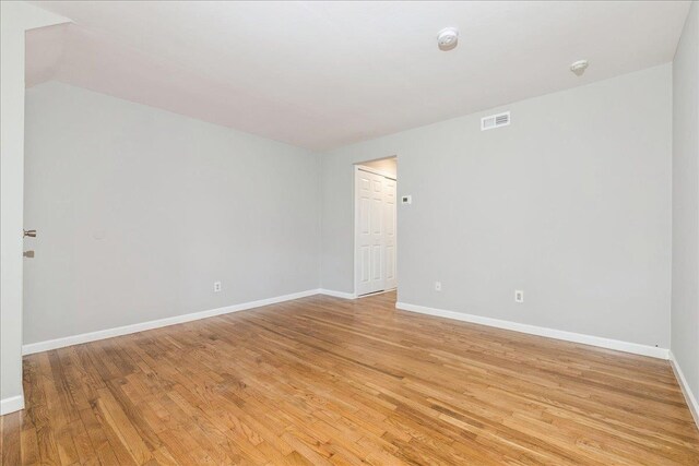152 Artist Lake Dr Unit 152, Middle Island, NY 11953 - empty room with light wood-style floors, baseboards, a smoke detector, and lofted ceiling
